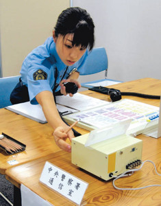 競技会で無線で指示を出す通信指令係の警察官＝県警本部で