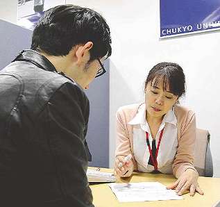 大学職員に入社志望書の添削を受ける学生（左）＝１８日、名古屋市昭和区の中京大で