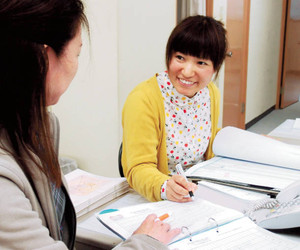 介護事業所で同僚と打ち合わせをする林未来さん＝千葉県松戸市で