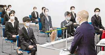入社式で中部国際空港会社の犬塚力社長の話を聞く新入社員たち＝愛知県常滑市の中部国際空港で
