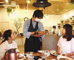 来店客に飲み物を運ぶスタッフ＝瑞穂区苗代町のカフェ「ｍａｇｎｅｔ」で