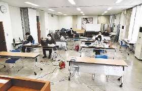 在宅勤務を導入した蟹江町では、出勤した職員も、密を避けるため、大会議室で仕事をする＝同町役場で