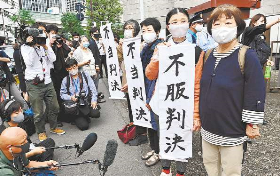 メトロコマースの待遇格差を巡る上告審判決後、「不当判決」などの垂れ幕を掲げる原告団＝１３日午後、東京都の最高裁前で
