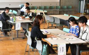 企業の採用担当者らの説明を聞く学生たち＝長久手市の愛・地球博記念公園で