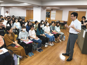 言語聴覚士などを目指す学生らに、自らの経験を語る池田さん（右から２人目）＝名古屋市中村区の東海医療科学専門学校で