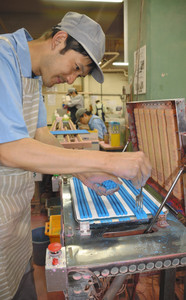 余分なチョークをフォークで突き刺して取り除く社員＝川崎市で