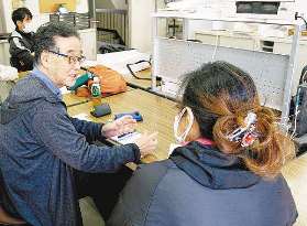 ユニオン愛知の森博和書記長（左）と労働契約などについて話すアリアさん＝名古屋市中村区で