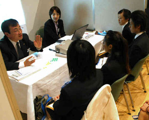 関心のある企業のブースを訪れ、担当者（左）の話に耳を傾ける学生たち＝昨年１２月、長野市内で