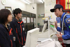 コンビニ店員に注意を促す警備員＝伊勢市で