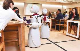 期間限定でオープンしたカフェで商品を客席に運び、会話をする分身ロボット＝７日、東京都千代田区で