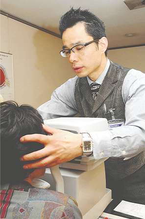 レンズ選びに欠かせない「検眼」をする早川さん＝安城市御幸本町で