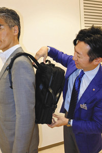 岩崎好博さん（右）は「背中とリュックの間に隙間があったら下げすぎ」と話す高島屋で＝名古屋市のジェイアール名古屋