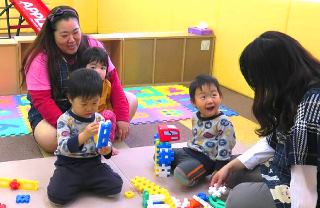 社員寮１階の保育所で保育士と遊ぶ子どもたち＝名古屋市守山区の伸和キッズランドで