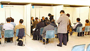 企業ごとのブースで、担当者と面接する来場者＝金沢市文化ホールで