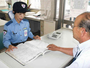 警察官の留守を預かり、住民に対応する交番相談員の畠山さん（左）＝四日市市の四郷交番で