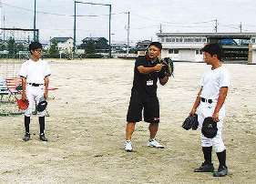 指導員（中）から捕球の仕方を教わる野球部員たち　＝いずれも飛島村の飛島学園で