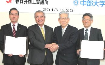 握手を交わす松尾会頭（左から２人目）と山下学長（同３人目）＝春日井市鳥居松町の春日井商工会館で