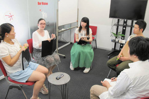 井戸端会議で意見交換をする社員＝大阪市北区のコンビーズで