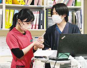 診療看護師を目指し業務に励む水谷さん（左）と田中さん＝三重県四日市市の四日市消化器病センターで
