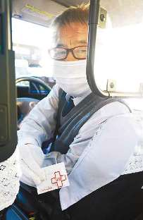 感染防止のため降車時に除菌シートを渡す乗務員＝大垣市で