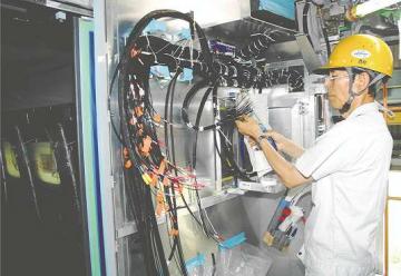 たくさんの電線を１本ずつ接続していく西村幸男さん＝豊川市穂ノ原の日本車両豊川製作所で