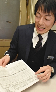 「イクメンサポート面談」で使用するスケジュール表を手に、育休体験を語る安藤さん＝県庁で