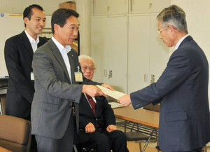 経済団体幹部（右）に要請書を手渡す県と三重労働局の担当者ら＝津市内で
