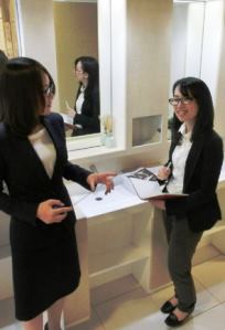 女性の意見を取り入れて開発した女性トイレの洗面台で意見を交わすアイカ工業の伊藤麻衣さん（右）ら＝名古屋市千種区で