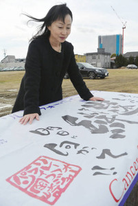 リレー・フォー・ライフの大会旗を見つめる山口史依さん。「がんになっても働ける」と感じている＝愛知県岡崎市で