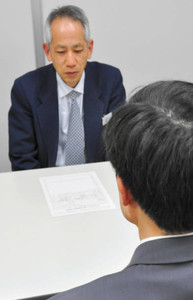 相談員（奥）に労働問題を相談する男性＝名古屋市中村区名駅で