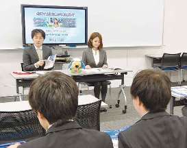 学生たちを前に仕事の内容を説明する職員ら（奥）＝名古屋市中村区の愛知大名古屋キャンパスで